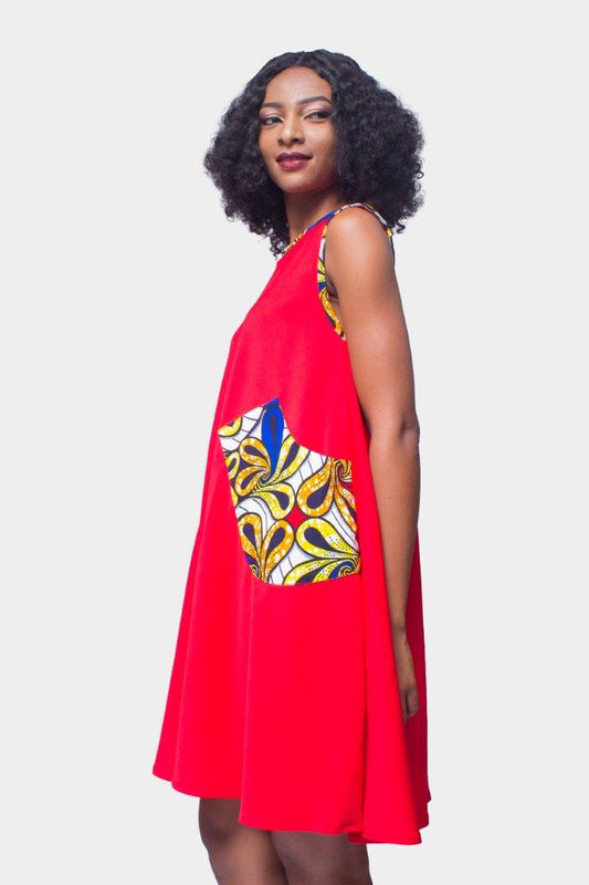 Shift Dress featuring a sleeveless, flowing red jersey mini dress accented with colorful geometric African print accents at the shoulders and large curved side patch pockets