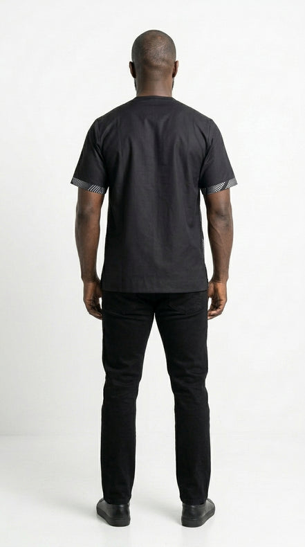 Shirt featuring a short-sleeved silhouette with a black and white optical diamond Ankara print on the chest, contrasted by solid black sleeves, collar, and side panels.