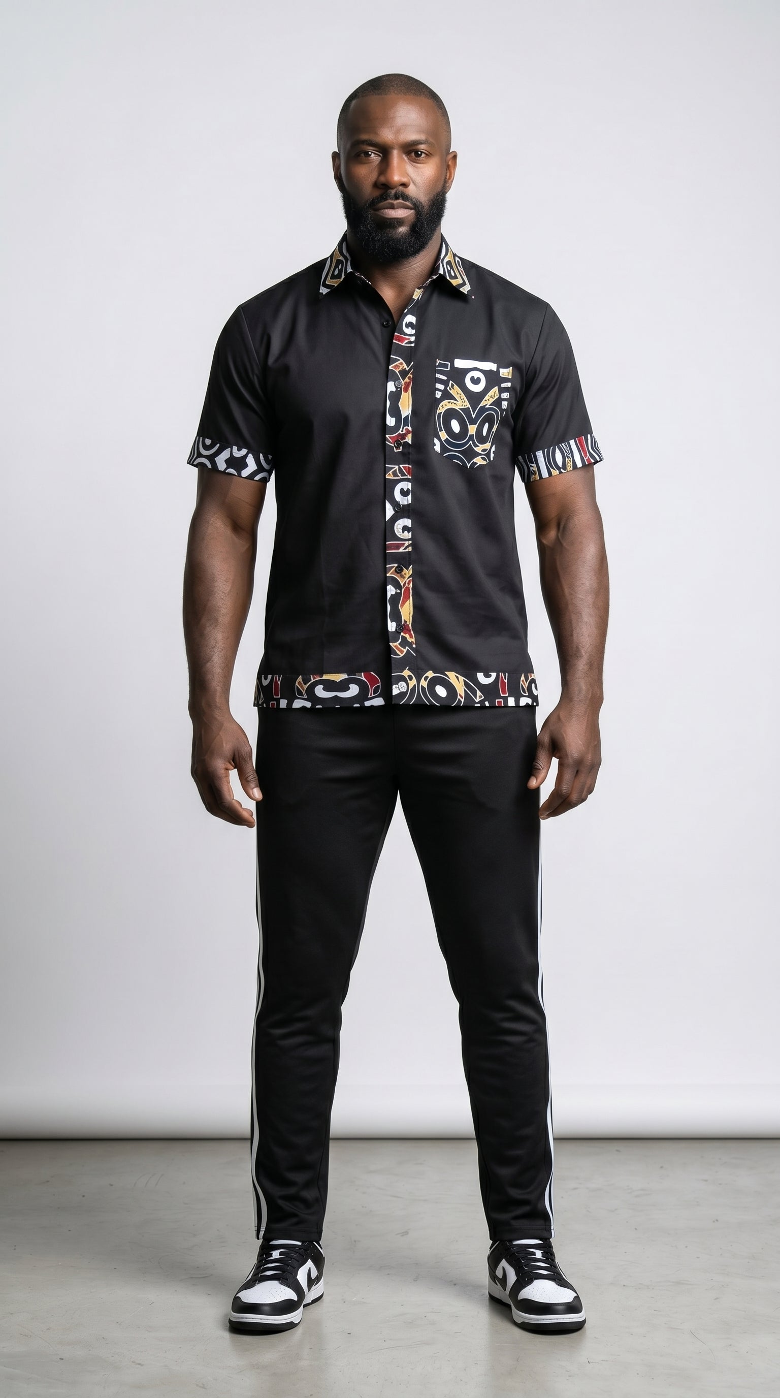 Shirt featuring a short-sleeved black button-down silhouette with vibrant graphic Ankara prints on the collar, pocket, central placket, and hem.