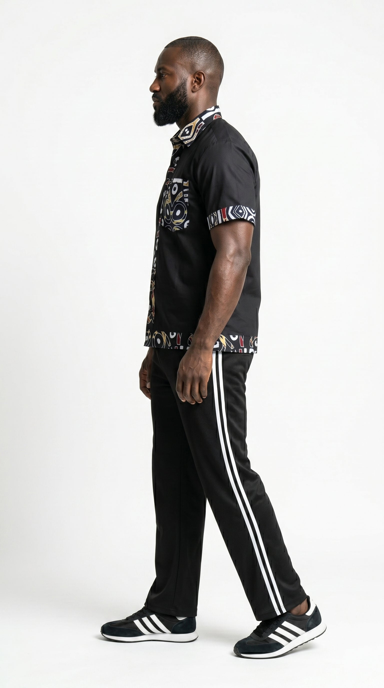 Shirt featuring a short-sleeved black button-down silhouette with vibrant graphic Ankara prints on the collar, pocket, central placket, and hem.