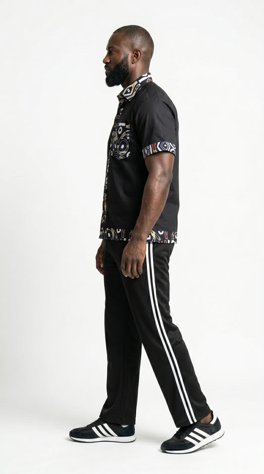 Shirt featuring a short-sleeved black button-down silhouette with vibrant graphic Ankara prints on the collar, pocket, central placket, and hem.