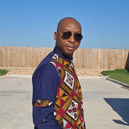 Shirt featuring a vibrant red, yellow, and white geometric Ankara print front panel paired with solid navy blue long sleeves with unique pleated cutouts.