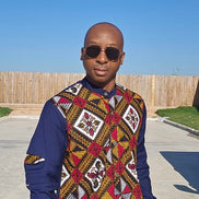 Shirt featuring a vibrant red, yellow, and white geometric Ankara print front panel paired with solid navy blue long sleeves with unique pleated cutouts.