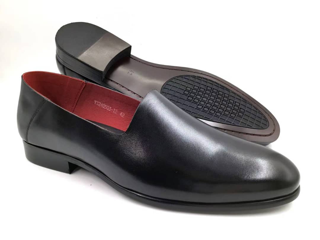 Smooth Grain Slip-On with its seamless matte black leather upper, vibrant scarlet red interior lining, and a low-profile dress sole.