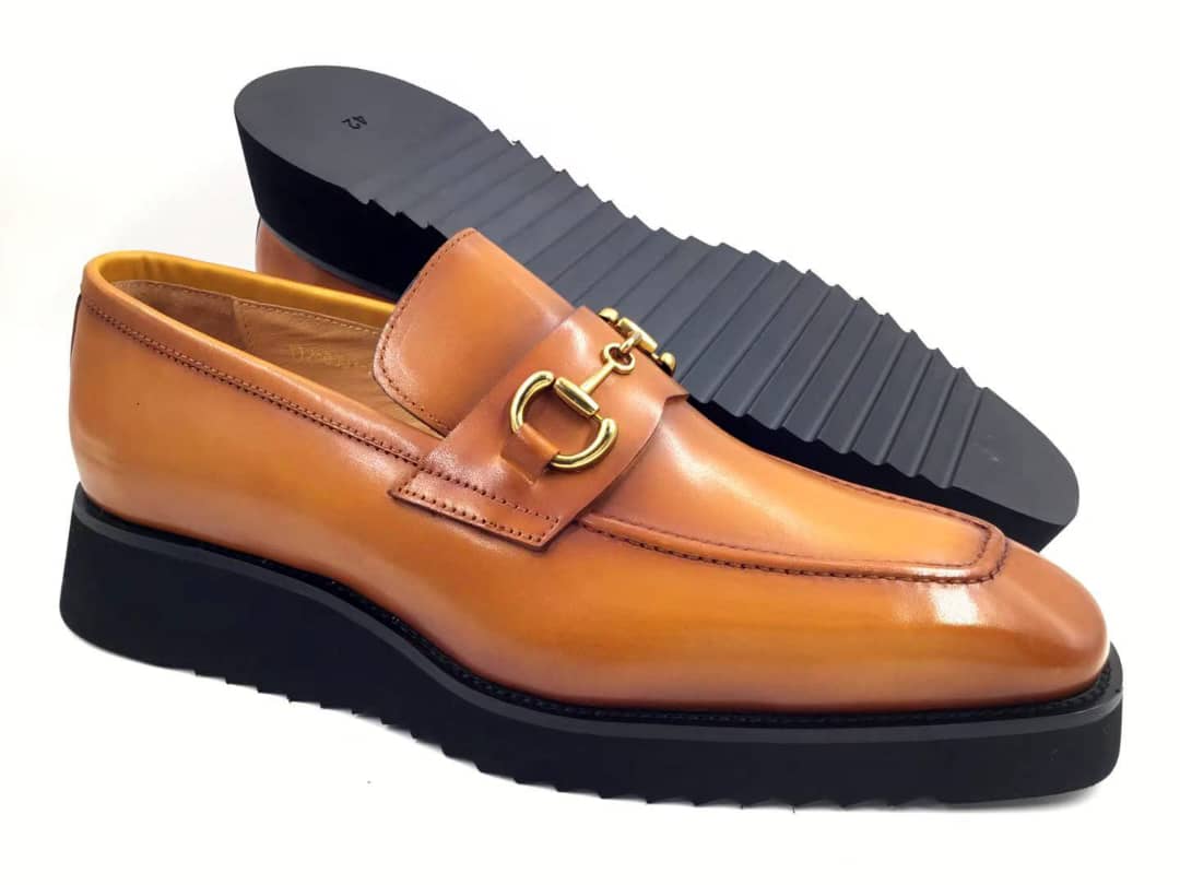 The Apex Bit Loafer  with its honey-toned burnished leather upper, gold horsebit accent, and a thick, black rippled platform sole.