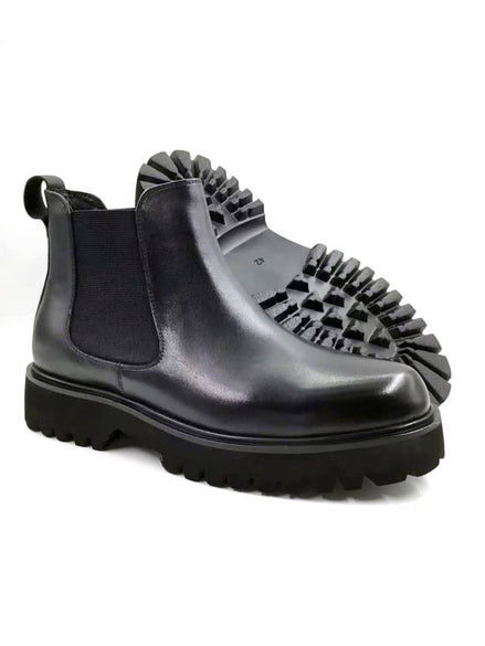 Chelsea Lug Boot with its smooth black leather upper, elastic side panels, and a thick, aggressive black lugged sole.