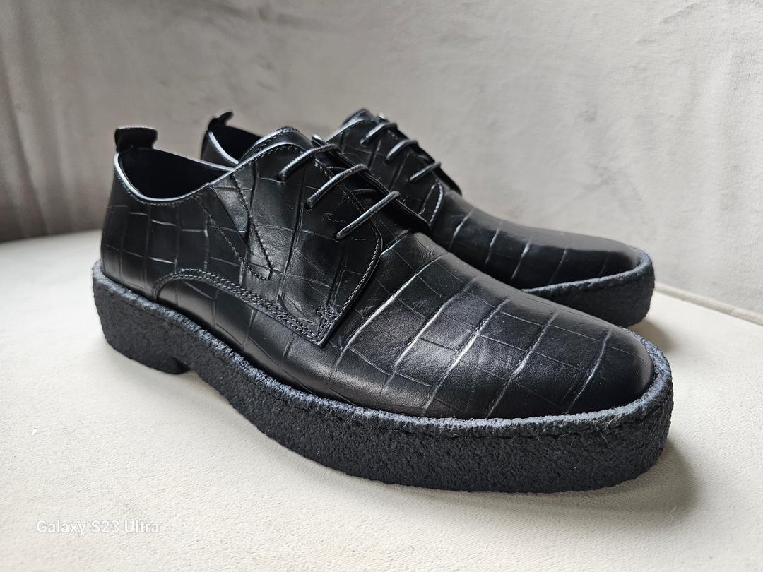 The Croc Derby with its black crocodile-embossed leather upper, three-eyelet lacing, and a thick, textured black and gum-colored crepe sole.