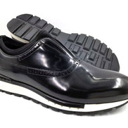 The Hybrid Brogue Runner with its high-shine black leather upper, traditional brogue perforations, black neoprene ankle collar, and a thick black and white high-traction sole.