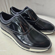 The Hybrid Brogue Runner with its high-shine black leather upper, traditional brogue perforations, black neoprene ankle collar, and a thick black and white high-traction sole.