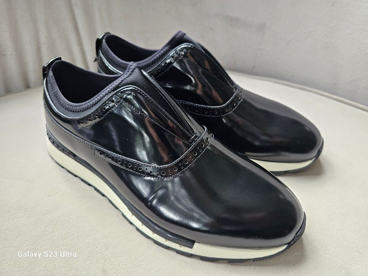 The Hybrid Brogue Runner with its high-shine black leather upper, traditional brogue perforations, black neoprene ankle collar, and a thick black and white high-traction sole.