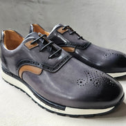 The Hybrid Derby featuring image_ae5dc9.jpg showing a slate-grey and tan leather upper, wingtip-style brogue perforations, and a white athletic outsole.