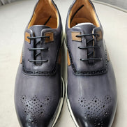The Hybrid Derby featuring image_ae5dc9.jpg showing a slate-grey and tan leather upper, wingtip-style brogue perforations, and a white athletic outsole.