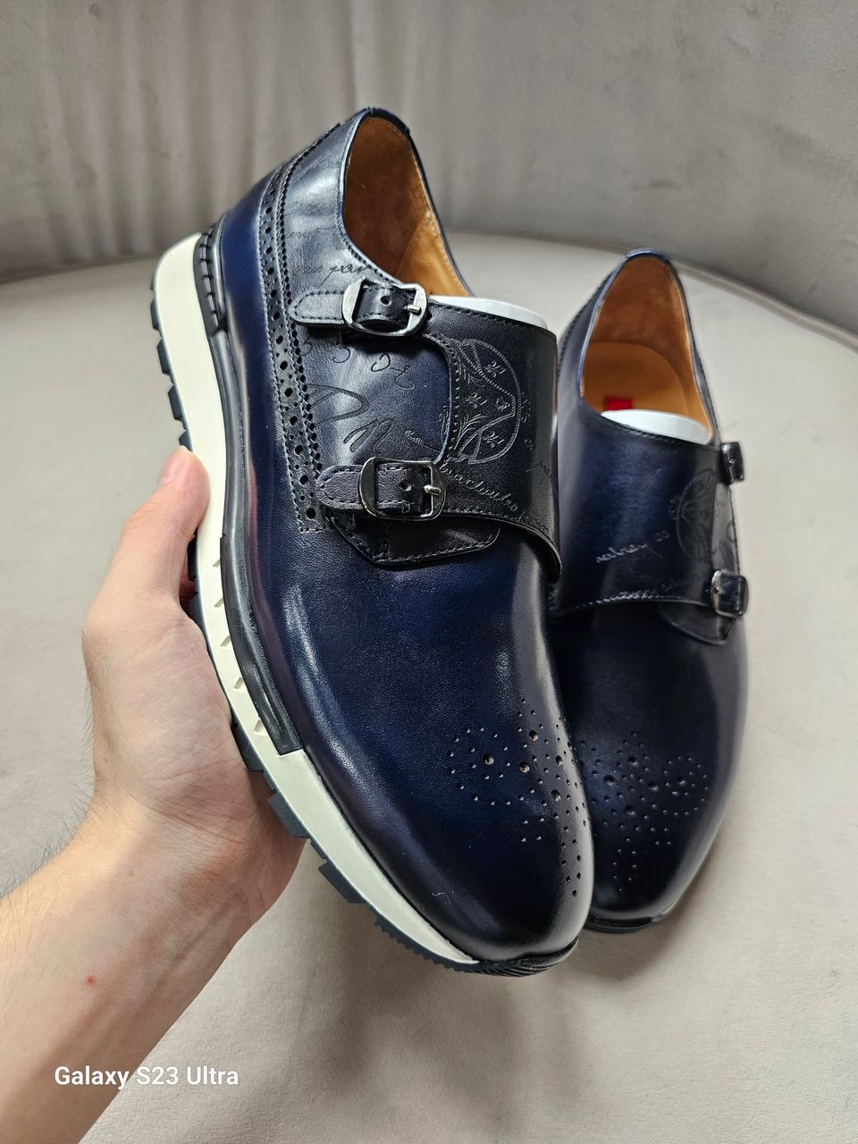 The Jigo Monk Double Monk Strap with its deep navy burnished leather, etched calligraphy on the double straps, and a contrasting white rugged outsole.