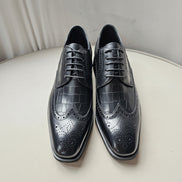 The Oba Wingtip with its multi-textured black leather design, croc-embossed vamps, and intricate wingtip brogue detailing.