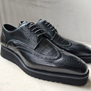 The Oba Wingtip with its multi-textured black leather design, croc-embossed vamps, and intricate wingtip brogue detailing.