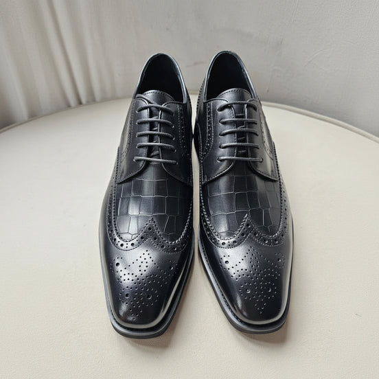 The Oba Wingtip with its multi-textured black leather design, croc-embossed vamps, and intricate wingtip brogue detailing.