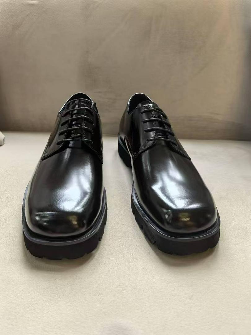 The Titan Lug Derby with its high-shine polished black leather, distinctive square-toe shape, and a thick, heavy-duty black lug sole.