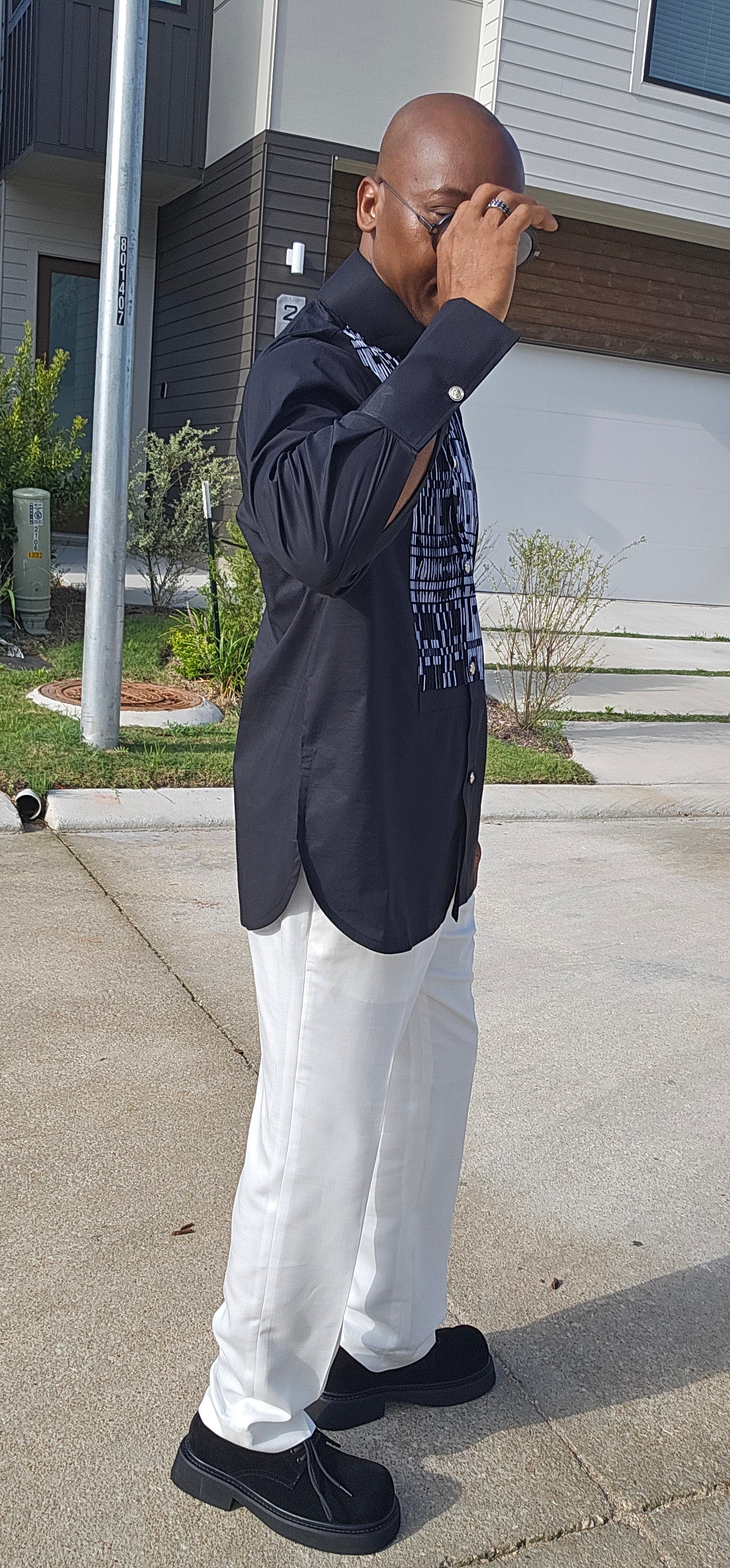 Top featuring a long-sleeved black tunic design with a geometric black-and-white print front panel and a high mandarin collar.