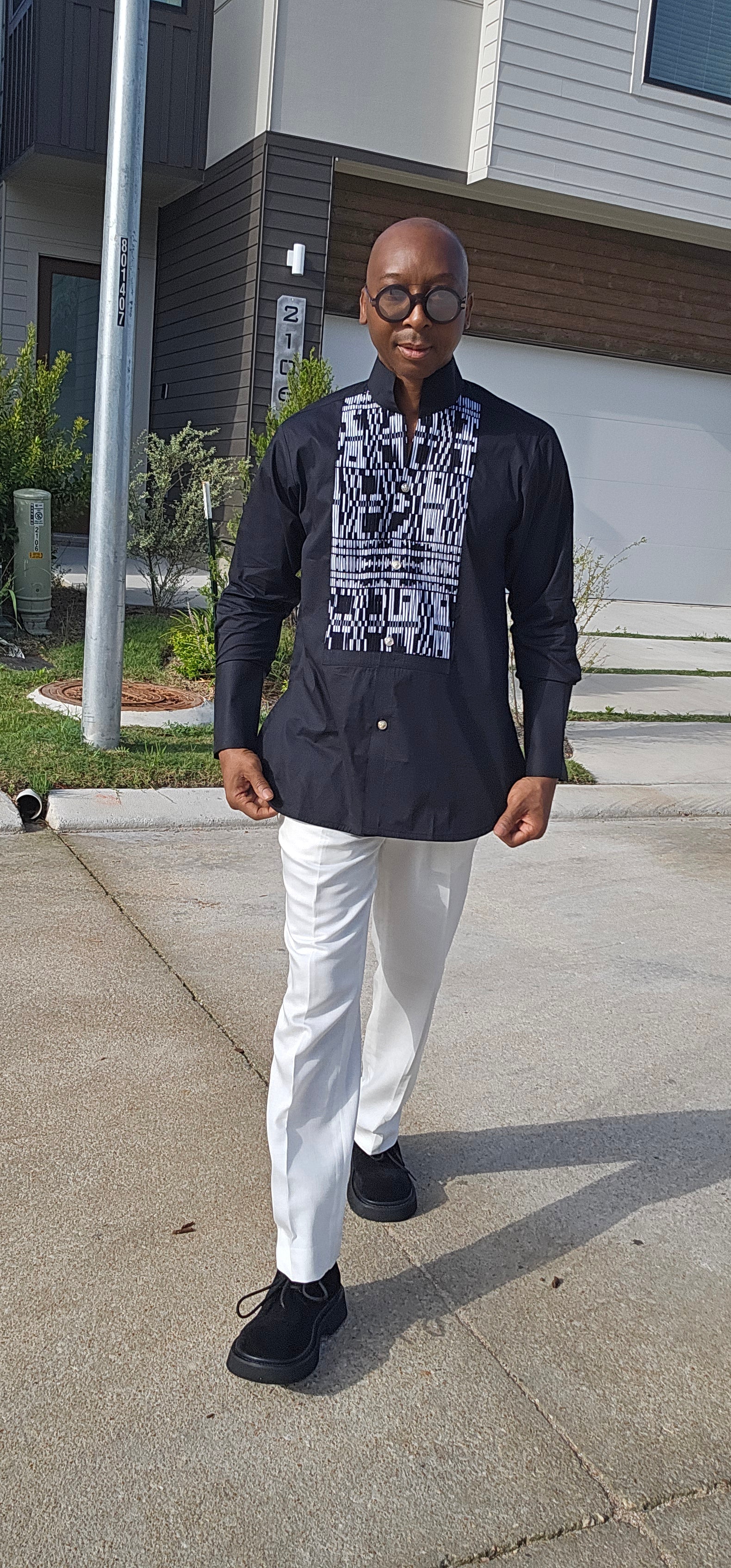 Top featuring a long-sleeved black tunic design with a geometric black-and-white print front panel and a high mandarin collar.