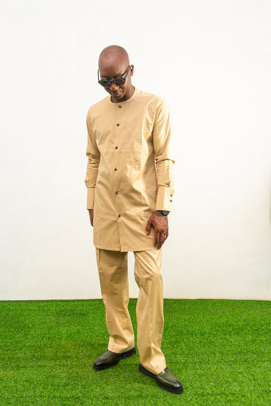 Traditional African outfit featuring a tan long-sleeved tunic with a round neckline, center-front button detailing, and matching structured trousers. Front View