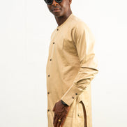 Traditional African outfit featuring a tan long-sleeved tunic with a round neckline, center-front button detailing, and matching structured trousers. Side View