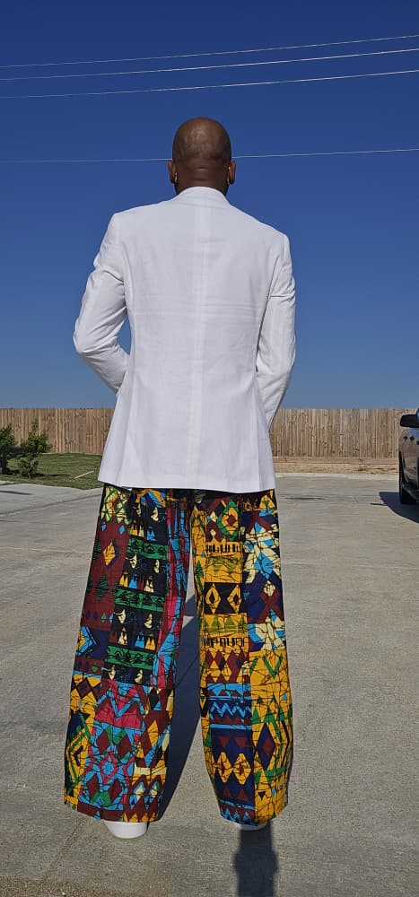 Trousers featuring a vibrant multi-colored geometric patchwork Ankara print in a dramatic wide-leg palazzo silhouette.