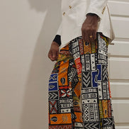 Trousers featuring a vibrant, multi-colored patchwork Ankara print with geometric and tribal motifs in a dramatic wide-leg silhouette.
