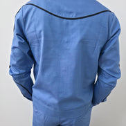 Azure blue two-piece set featuring a long-sleeved cowboy-style jacket with black western piping and matching tailored trousers. -Back View