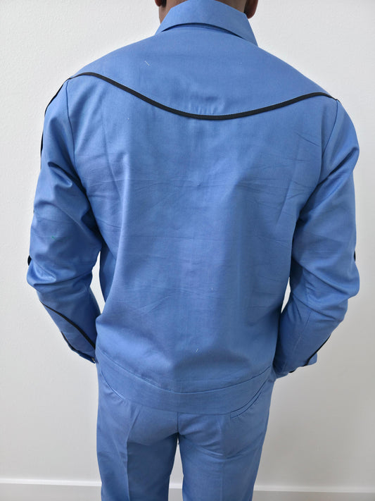 Azure blue two-piece set featuring a long-sleeved cowboy-style jacket with black western piping and matching tailored trousers. -Back View
