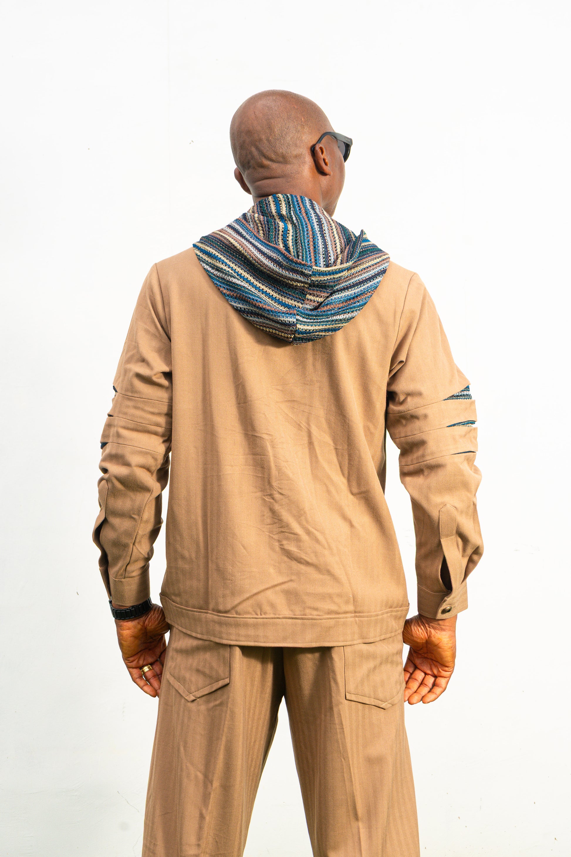 Two-Piece Set featuring a brown long-sleeved hooded shirt with blue patterned sleeve accents and matching straight-leg trousers.