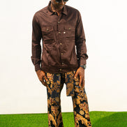 Two-Piece Set featuring a chocolate brown long-sleeve button-down shirt with metallic hardware and ornate gold and navy patterned palazzo trousers.
