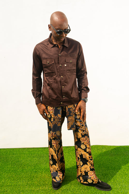 Two-Piece Set featuring a chocolate brown long-sleeve button-down shirt with metallic hardware and ornate gold and navy patterned palazzo trousers.
