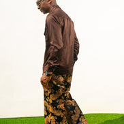 Two-Piece Set featuring a chocolate brown long-sleeve button-down shirt with metallic hardware and ornate gold and navy patterned palazzo trousers. Back View