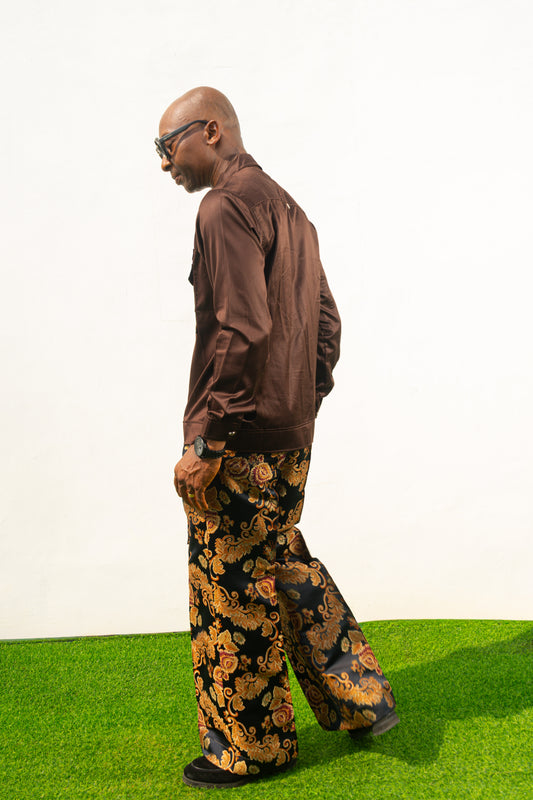 Two-Piece Set featuring a chocolate brown long-sleeve button-down shirt with metallic hardware and ornate gold and navy patterned palazzo trousers. Back View