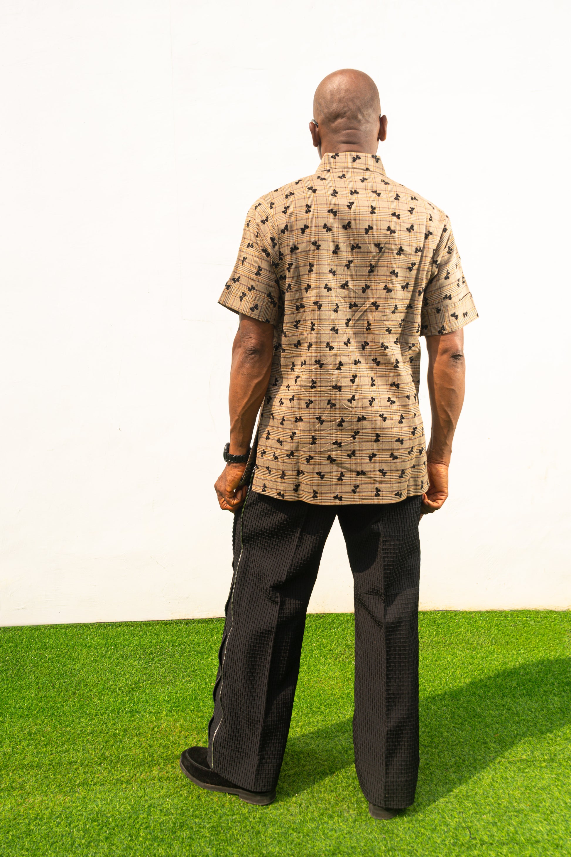 Two-Piece Set  featuring a short-sleeved patterned brown shirt with asymmetric buttons and coffee brown corduroy boot-cut trousers. Back View