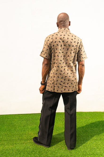 Two-Piece Set  featuring a short-sleeved patterned brown shirt with asymmetric buttons and coffee brown corduroy boot-cut trousers. Back View