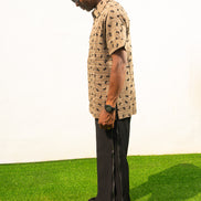 Two-Piece Set featuring a short-sleeved patterned brown shirt with asymmetric buttons and coffee brown corduroy boot-cut trousers. Side View