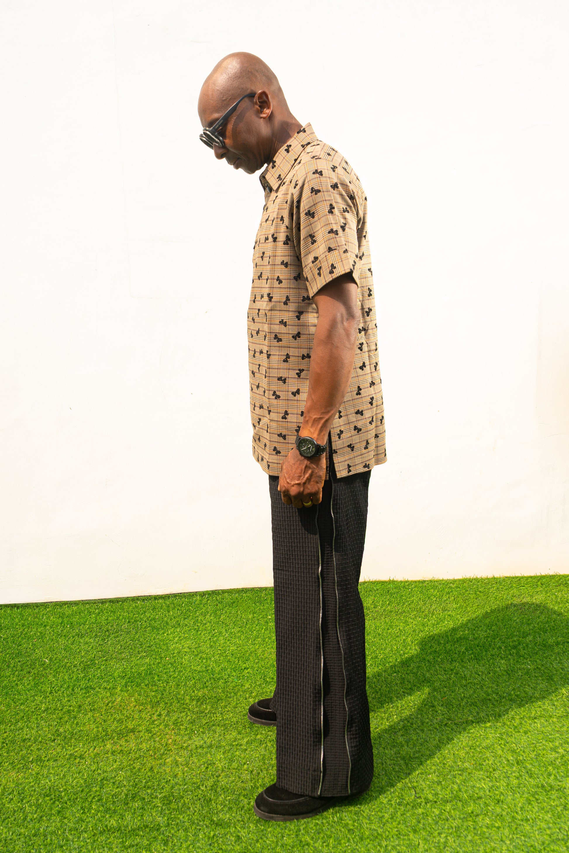 Two-Piece Set featuring a short-sleeved patterned brown shirt with asymmetric buttons and coffee brown corduroy boot-cut trousers. Side View