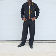 Two-Piece Set featuring a black virgin wool cropped zip-up jacket and wide-leg trousers accented by thin red, yellow, and green Ankara patterned piping.
