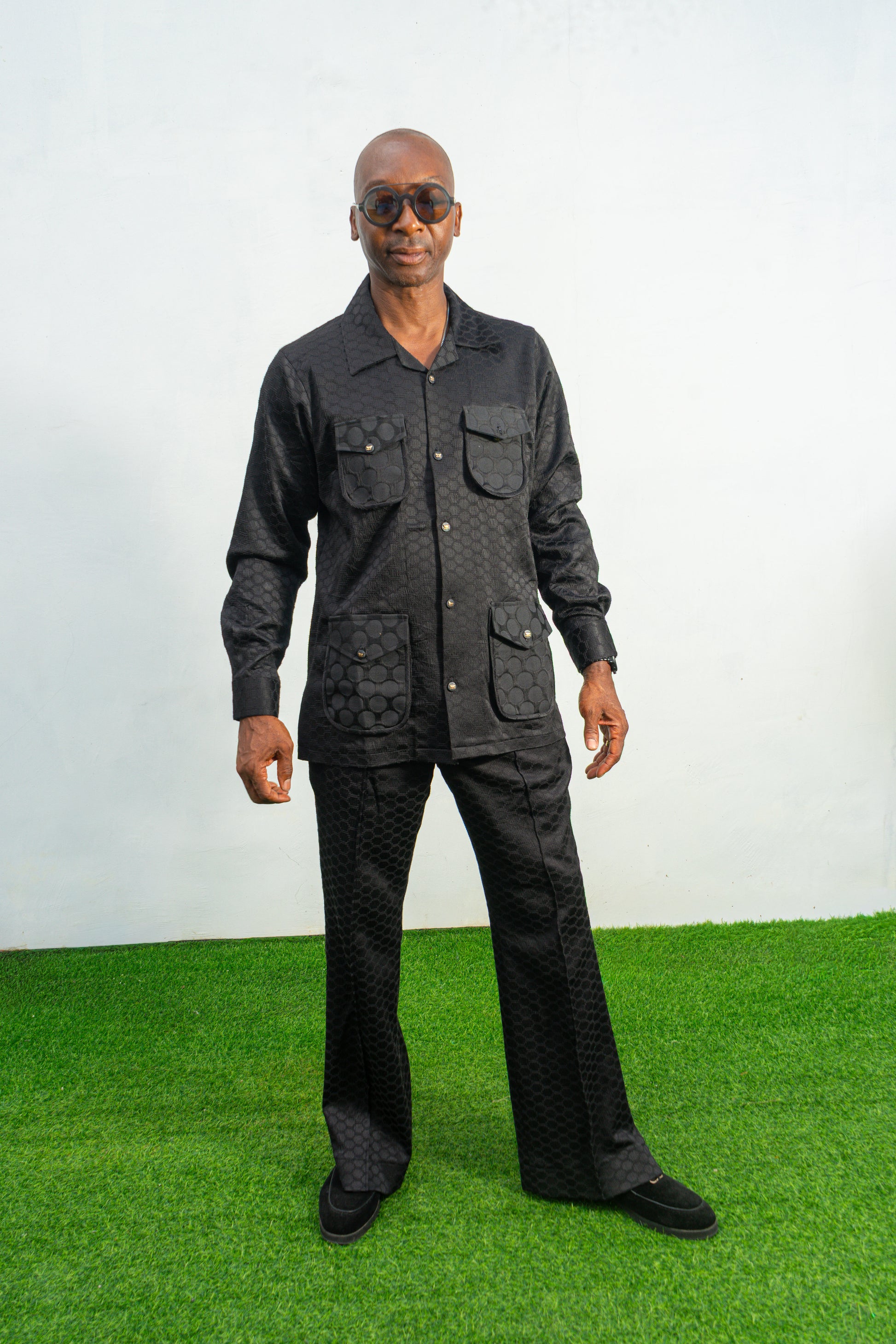 Two-Piece Set featuring a black textured viscose safari-style button-down shirt with four utility pockets and matching boot-cut trousers.