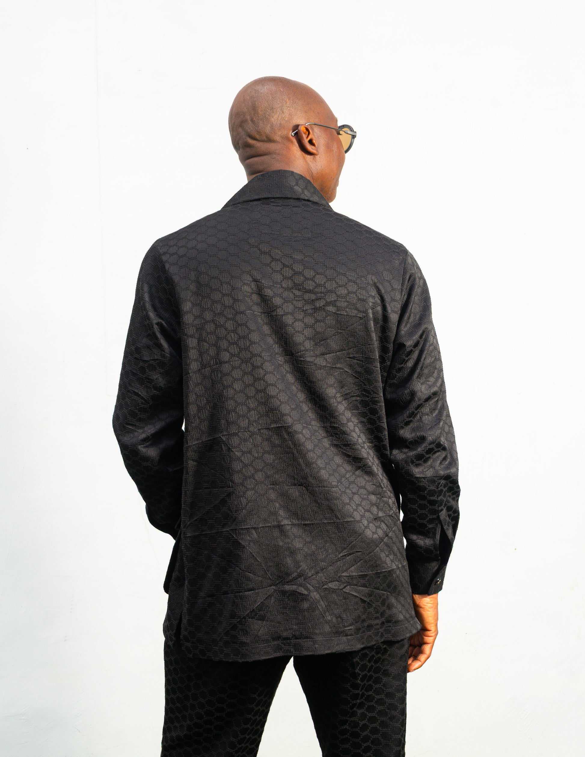 Two-Piece Set featuring a black textured viscose safari-style button-down shirt with four utility pockets and matching boot-cut trousers.