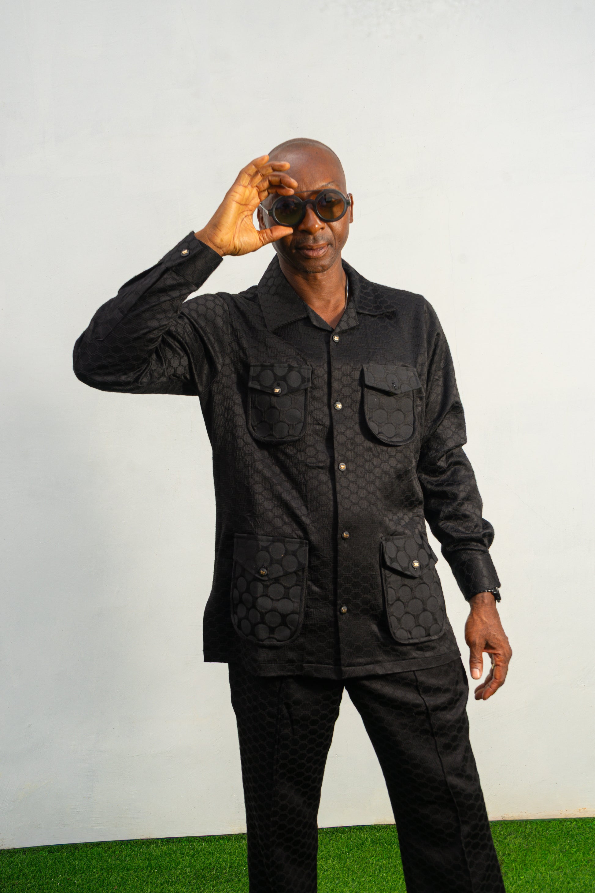 Two-Piece Set featuring a black textured viscose safari-style button-down shirt with four utility pockets and matching boot-cut trousers.