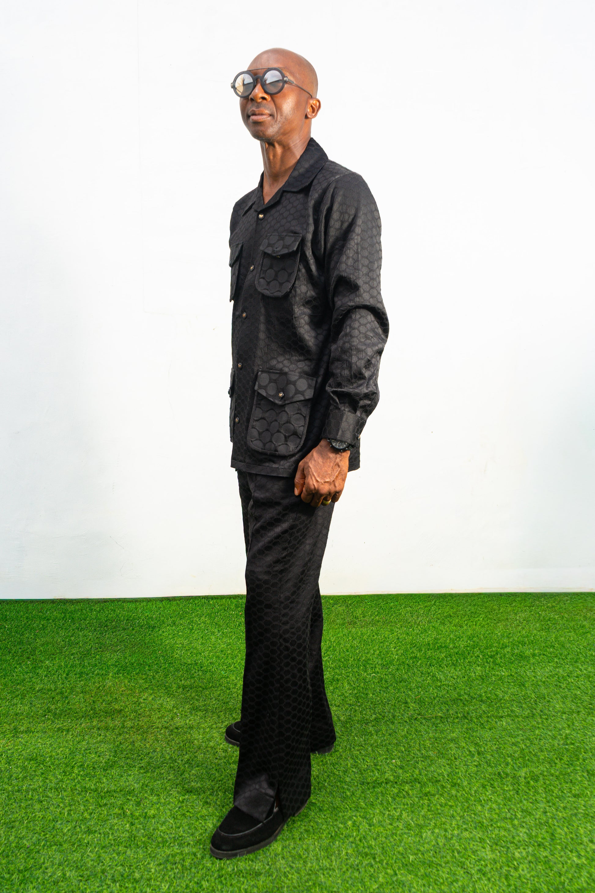 Two-Piece Set featuring a black textured viscose safari-style button-down shirt with four utility pockets and matching boot-cut trousers.