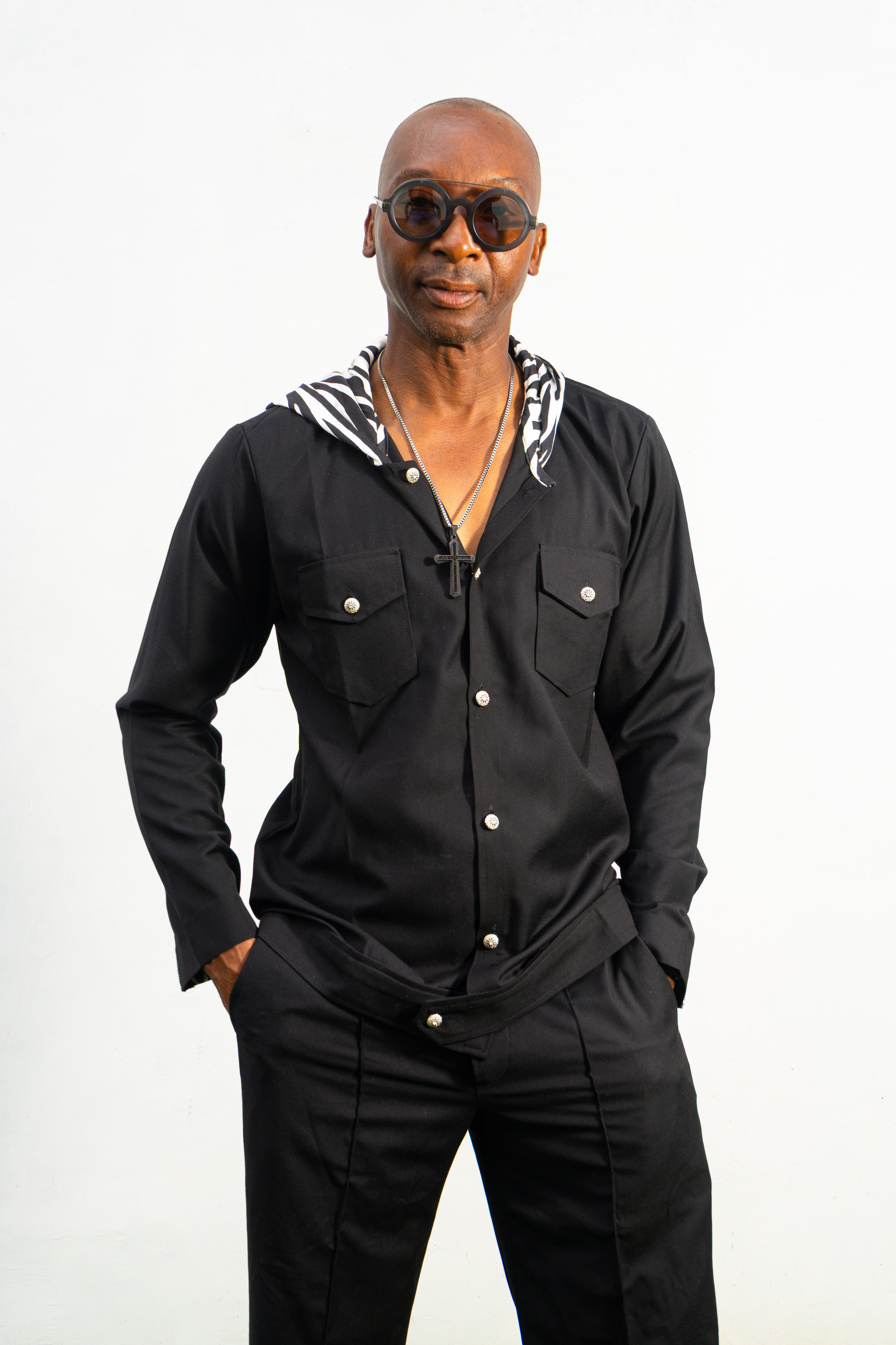 Two-Piece Set featuring a black hooded button-down shirt with zebra-print hood lining and matching black flared trousers with front-seam detailing.
