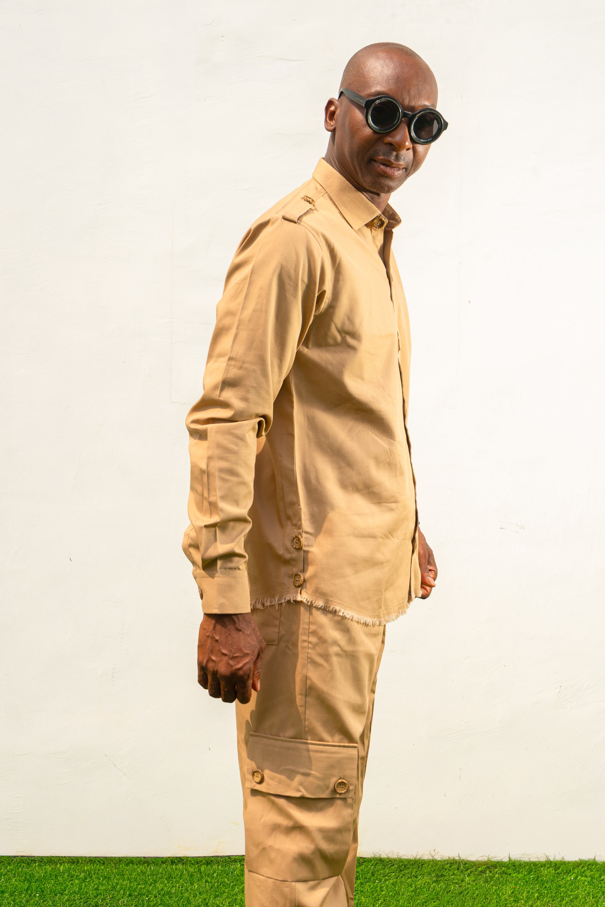 Two-Piece Set featuring a beige long-sleeved button-down shirt with shoulder epaulets and matching cargo-style trousers with side pockets.