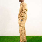 Two-Piece Set featuring a beige long-sleeved button-down shirt with shoulder epaulets and matching cargo-style trousers with side pockets. 