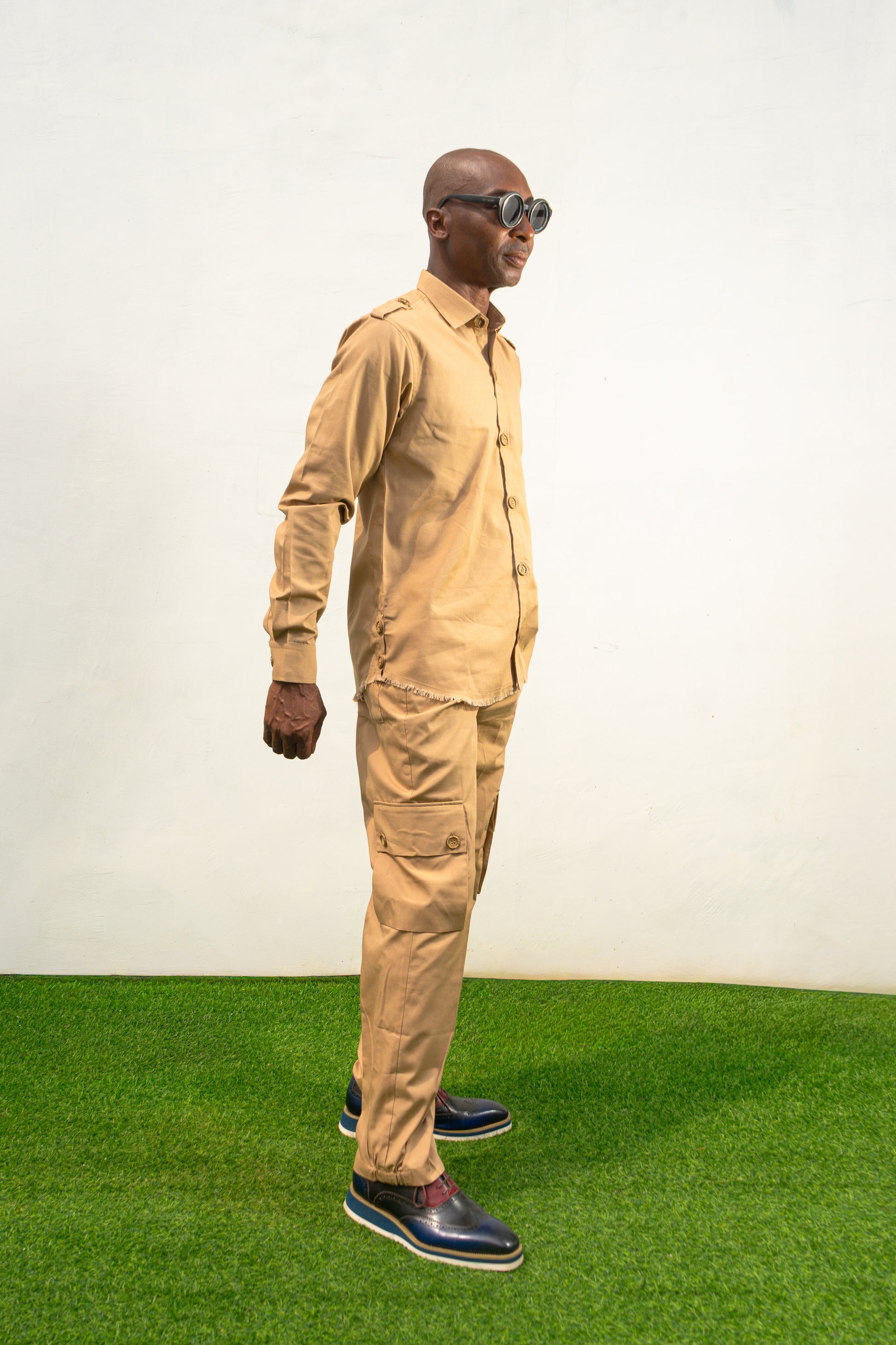 Two-Piece Set featuring a beige long-sleeved button-down shirt with shoulder epaulets and matching cargo-style trousers with side pockets.