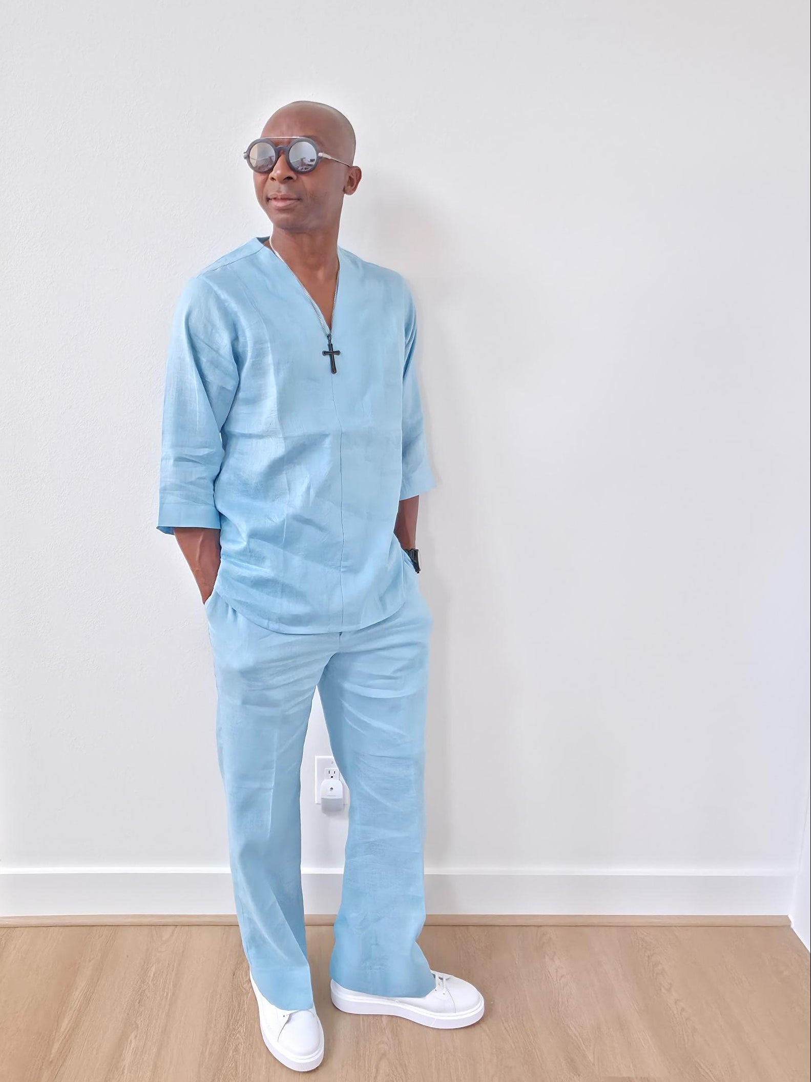 Sky blue linen two-piece set featuring a V-neck tunic with three-quarter sleeves and matching relaxed-fit trousers. -Leaning