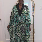 Patterned Boubou Kaftan featuring a green and black concentric circular print, a solid black V-neckline, and a wide-wing silhouette.