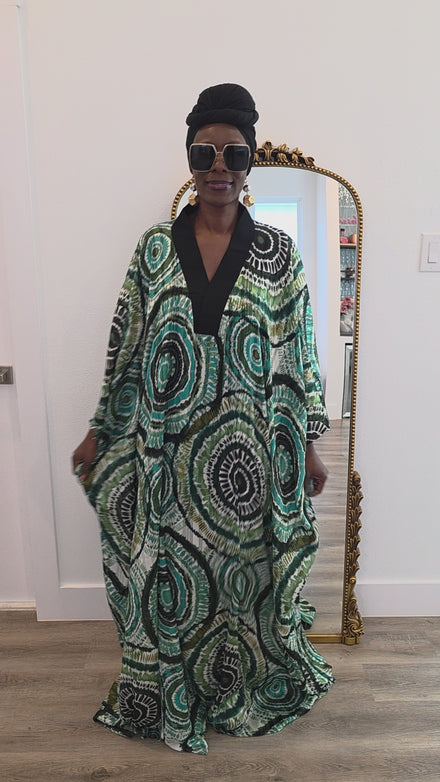 Patterned Boubou Kaftan featuring a green and black concentric circular print, a solid black V-neckline, and a wide-wing silhouette.